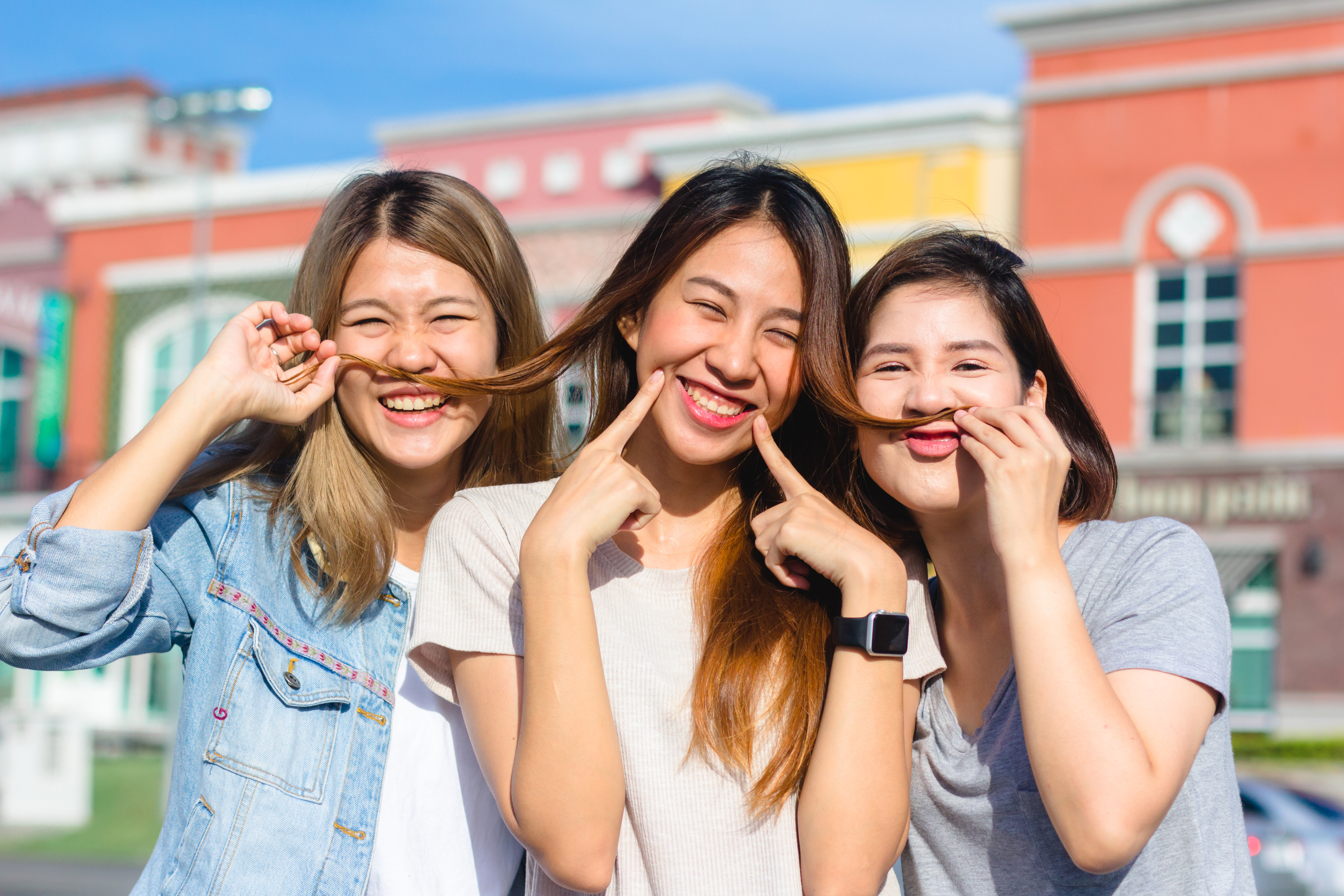 Happy young Asian women group city lifestyle playing and chattin